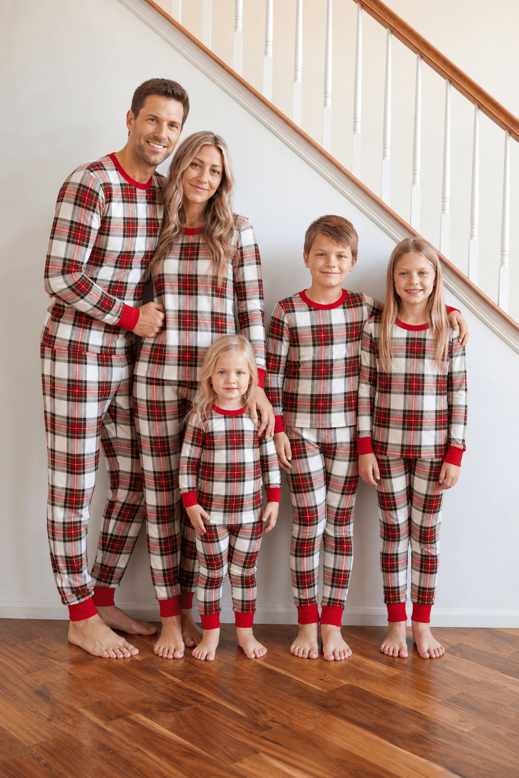 Family wearing matching cream and red tartan Christmas pyjamas with red ribbed cuffs - view 2
