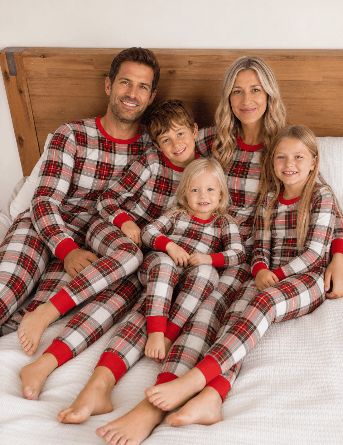 Family wearing matching cream and red tartan Christmas pyjamas with red ribbed cuffs - view 3
