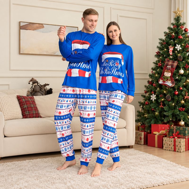 Couple in matching Christmas pajamas with blue Santa hat graphic top and patterned pants - view 2