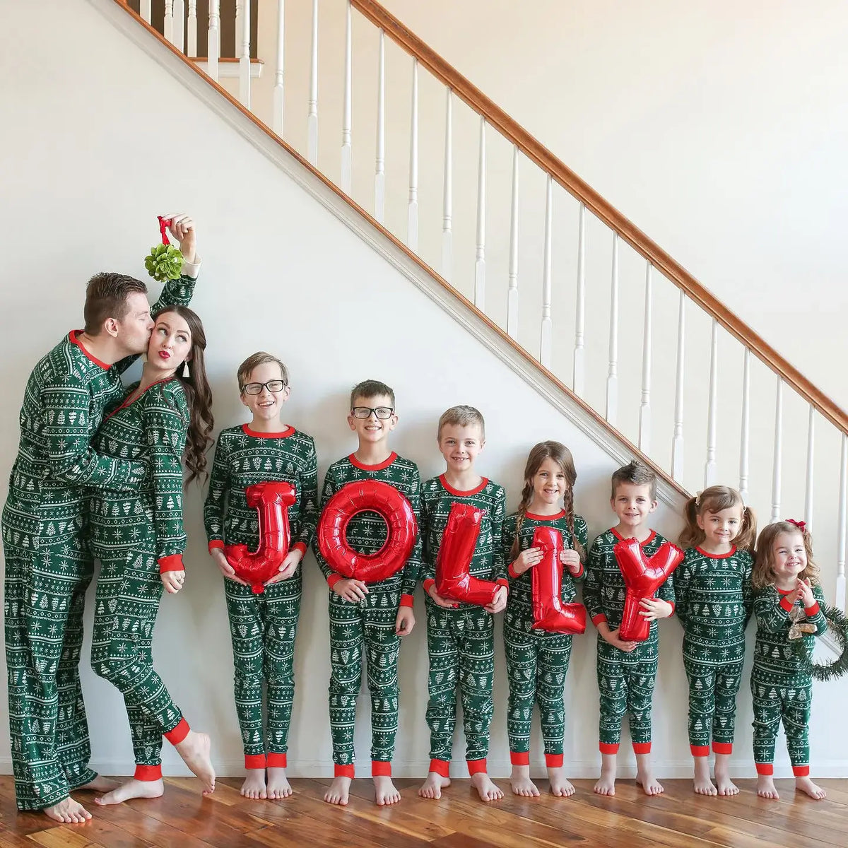 Family wearing matching green Fair Isle print Christmas pyjamas with red ribbed cuffs - view 5