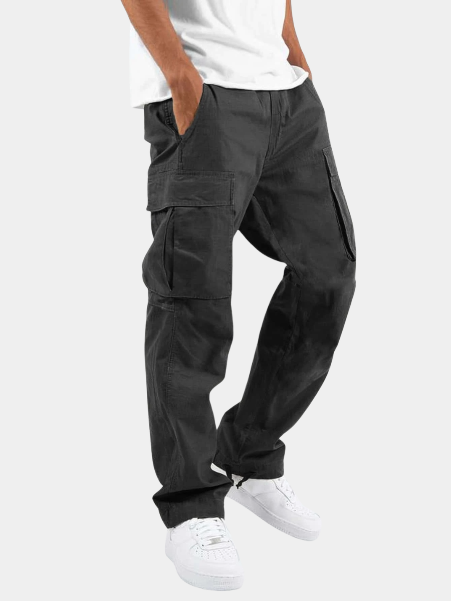 Relaxed fit mens cargo trousers with thigh flap pockets and drawcord hems, worn with a white tee and white trainers