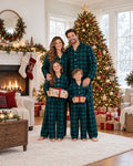 Family wearing matching green and navy tartan flannel Christmas pyjamas