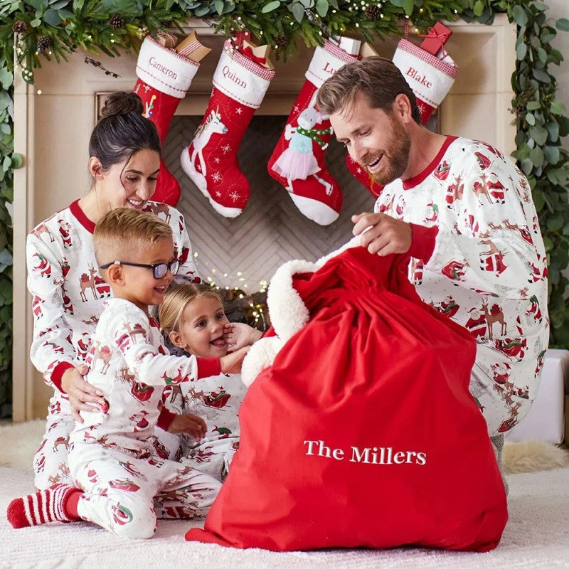 Matching family Christmas pyjamas with reindeer and Santa sleigh print and red ribbed trims