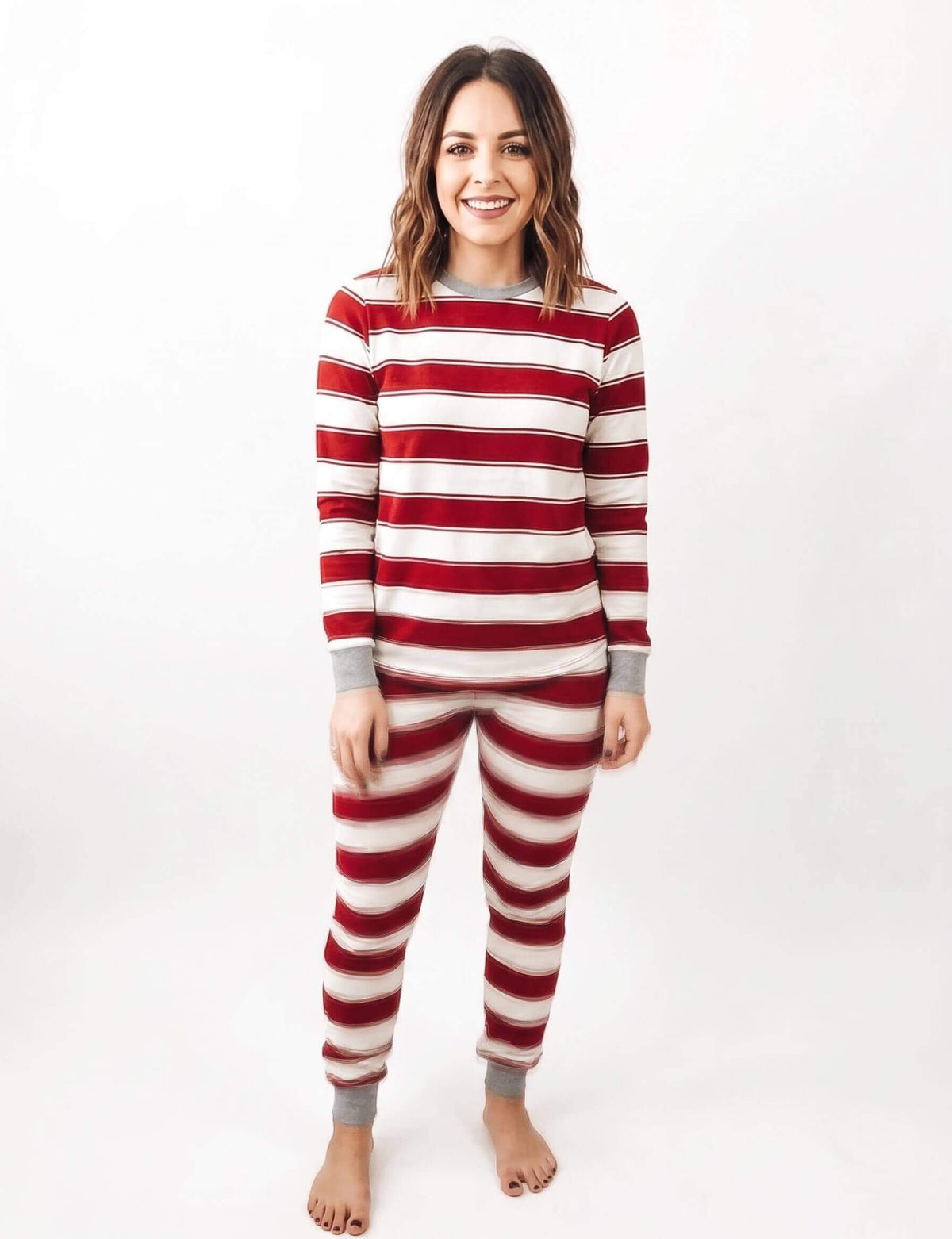 Family wearing matching red and white striped Christmas pyjamas with grey ribbed cuffs and a grey henley top - view 9
