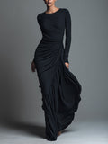 Woman in a black long sleeve knit maxi dress with ruched waist