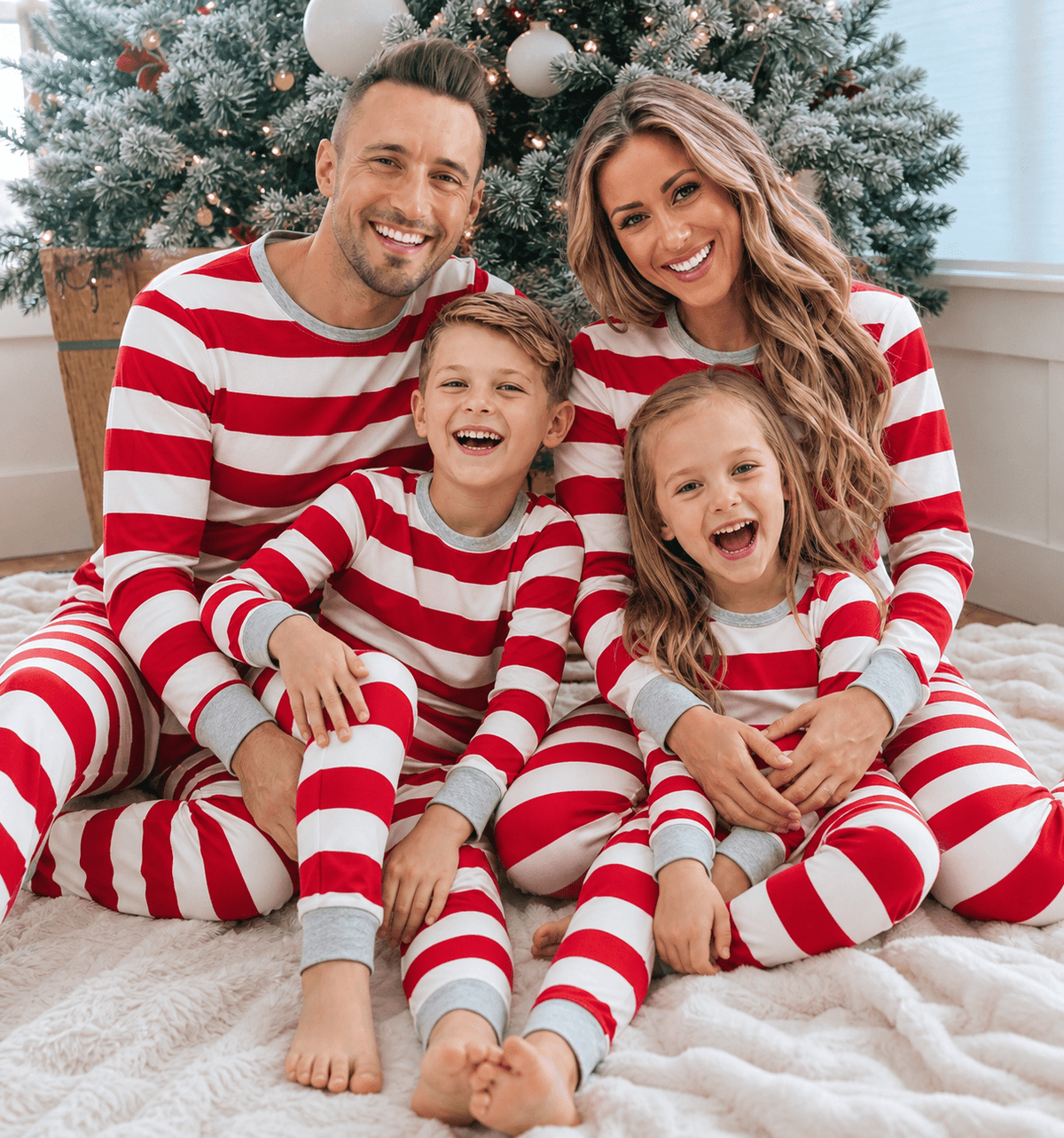 Family wearing matching red and white candy cane stripe Christmas pyjamas with grey ribbed trims - view 5