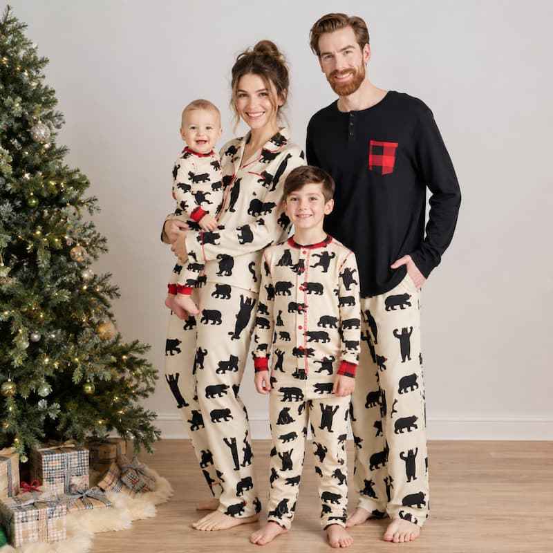 Men's bear print Christmas pajamas with black long-sleeve top by a fireplace
