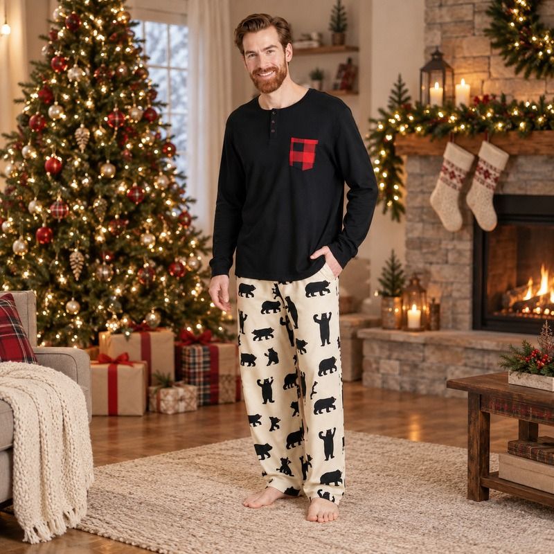Men's bear print Christmas pajamas with black long-sleeve top by a fireplace - view 3