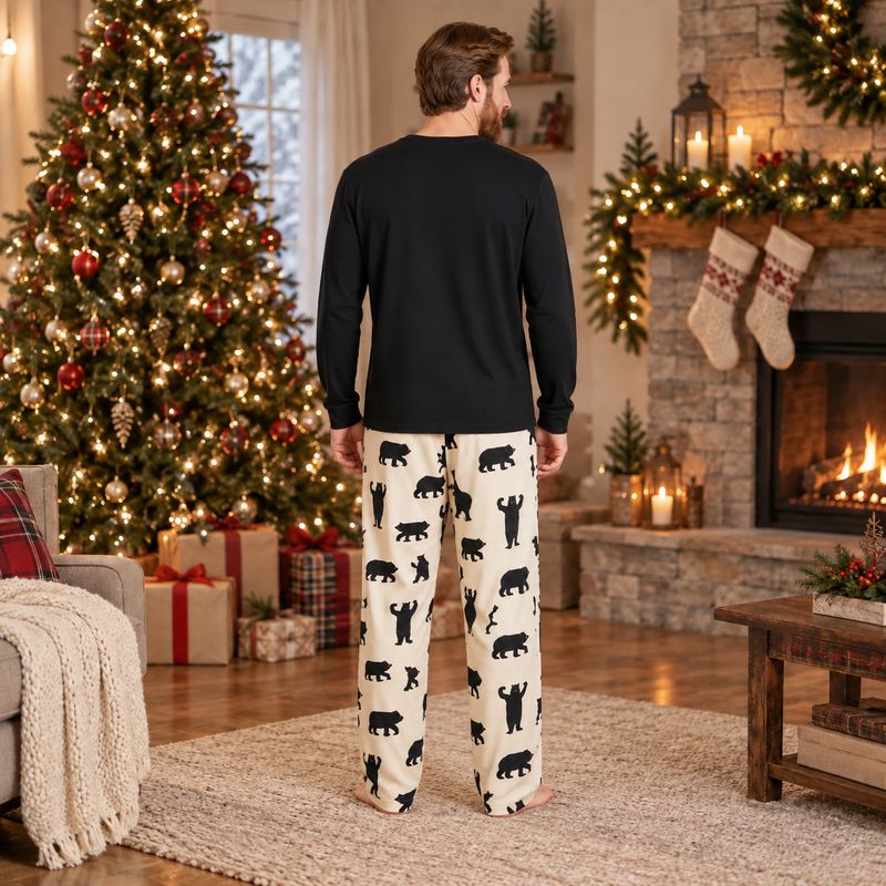 Men's bear print Christmas pajamas with black long-sleeve top by a fireplace - view 4